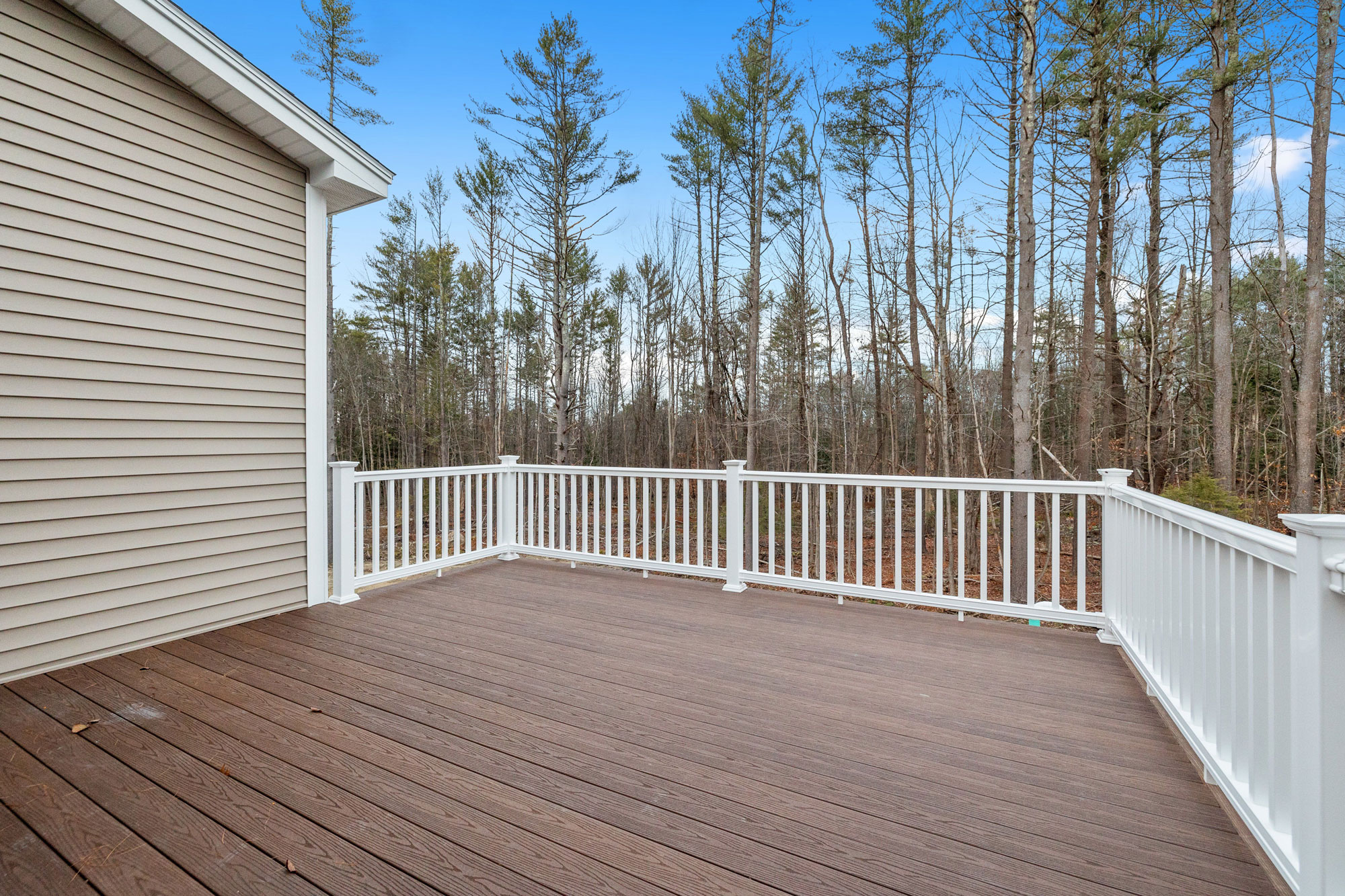 Composite deck with white railings built by Five Oaks Roofing Plus