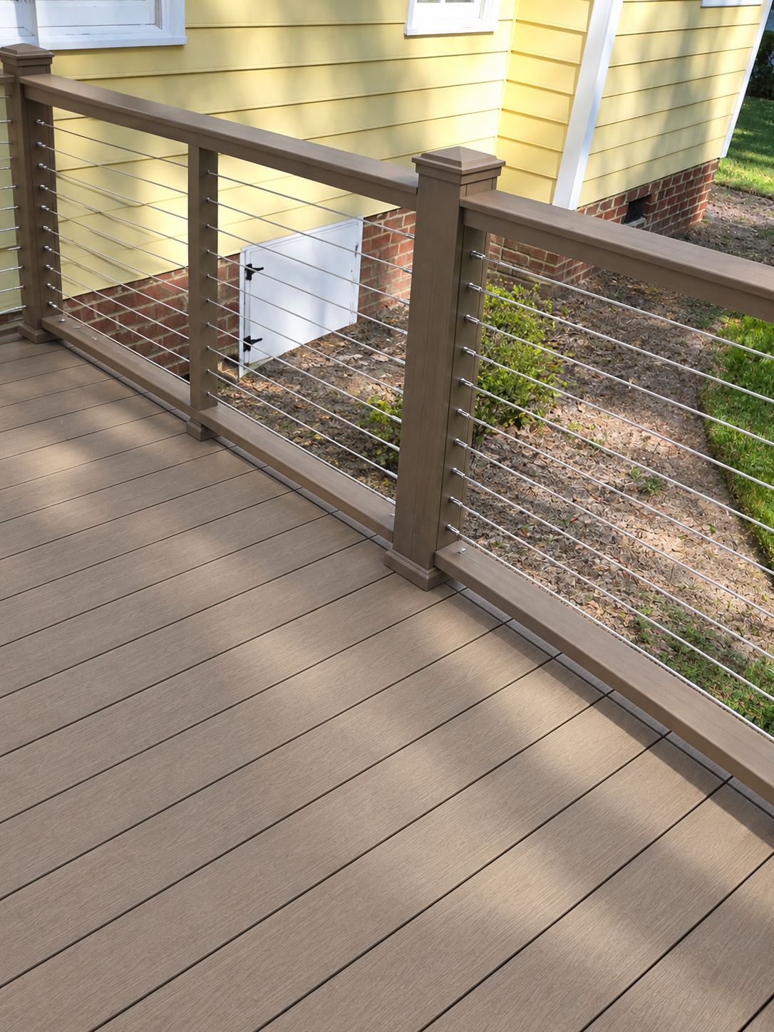 Composite deck with modern cable railing built by Five Oaks Roofing Plus